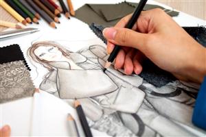 Artist sketching a woman wearing a fashionable coat, surrounded by colored pencils and fabric samples.