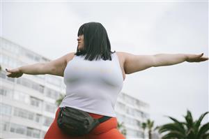 Woman stretches arms wide in exercise